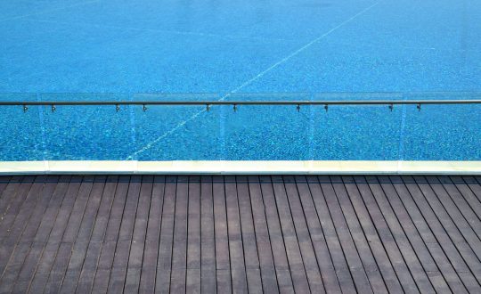 Outdoor Wooden Deck with Frameless Glass Balustrades and Stainless Steal Handrail — Pool Fencing in Benowa, QLD