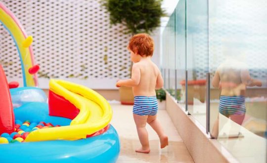 Kid On A Pool With Glass Fencing — Pool Fencing in Benowa, QLD